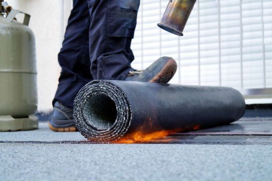 flat roof installation with propane blowtorch during construction works with roofing felt heating and melting bitumen roofing felt 1171113608 8ad3e6d357064dd4aa0095f13a968e13 36881